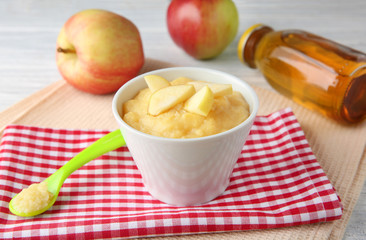 Bowl with porridge for baby on table