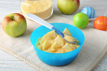 Bowl with porridge for baby on table