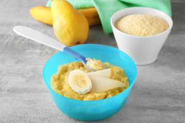 Bowl with porridge for baby on table