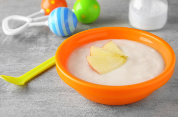 Bowl with porridge for baby on table