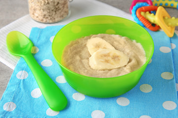 Bowl with porridge for baby on table