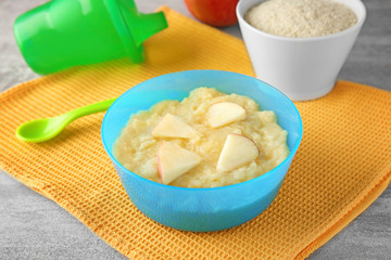 Bowl with porridge for baby on table