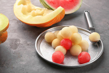 Metal dish with melon and watermelon balls on table