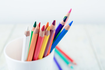 Color pencils in cup on light background, closeup