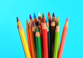 Fototapeta premium Color pencils on blue background, closeup