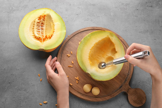 Woman making melon balls on table