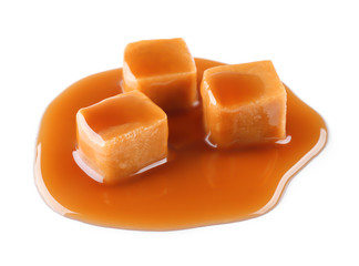 Sweet candies with caramel sauce on white background
