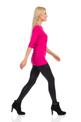 Fototapeta premium Smiling Blond Woman Is Walking. Side View. Isolated On White