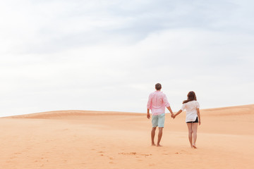 Young Man Woman Walking In Desert Couple Girl And Man Hold Hands Back Rear View Sand Dune Landscape Nature Background