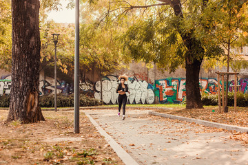 Jogger portrait running in urban autumnal park