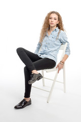 Fototapeta premium young modern and cheerful girl sitting on chair on white background