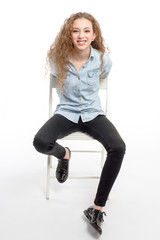 Fototapeta premium young modern and cheerful girl sitting on chair on white background