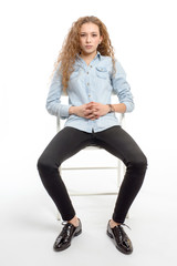 young modern and cheerful girl sitting on chair on white background