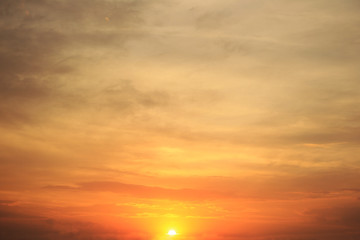 Fototapeta na wymiar Evening sky and orange sun at sunset, calm cloudscape