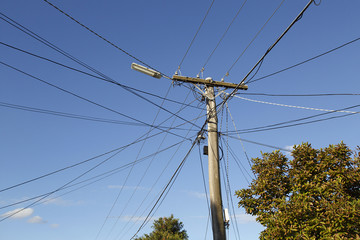 Telegraph pole with electrical wires and blue sky background