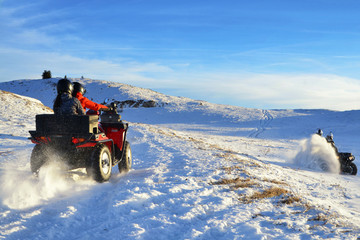 People enjoying while driving quad bike on top of mountain at winter time © nikolas_stock