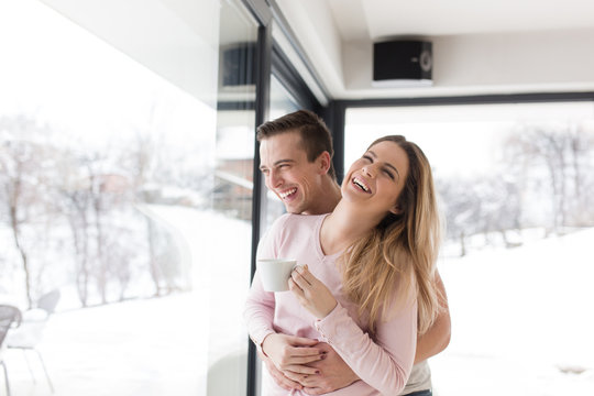 young couple enjoying morning coffee by the window