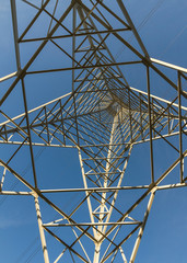 Torre de distribucion de electricidad vista desde abajo sobre fondo de cielo azul