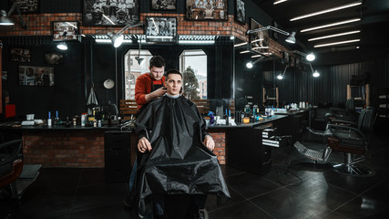 customer and barber/ Barber cutting in barbershop. Interior of hairdressing room