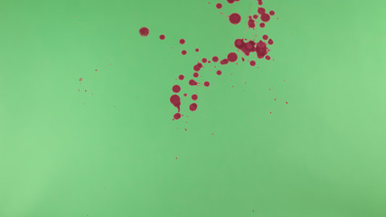 Red Ink Splatter Over Green Screen Background