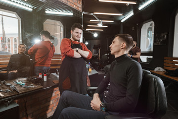 haircut is ready/ Barber evaluates the customer's haircut in the armchair