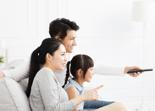 Happy family watching TV in living room