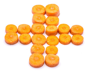 Group of sliced round orange carrot circles in the shape of cross like red cross emblem isolated on white background