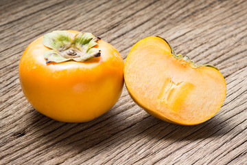 fresh persimmon fruit and section on old wood ( Diospyros virginiana L., EBENACEAE)