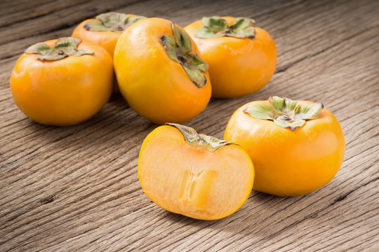 fresh persimmon fruit and section on old wood ( Diospyros virginiana L., EBENACEAE)