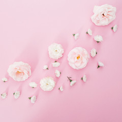 White roses arrangement on pink background. Flat lay, top view. Floral background.