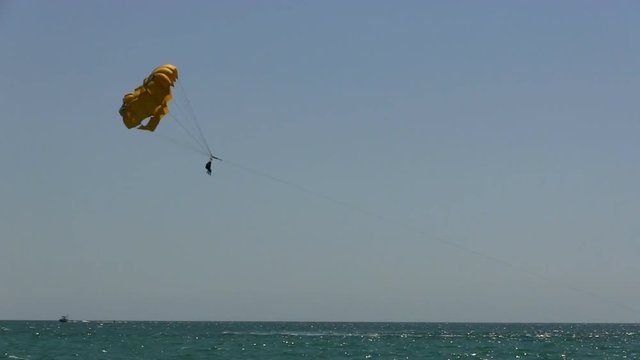 Vacation getaway adventure thrills parasailing in the Gulf of Mexico off Naples Florida.