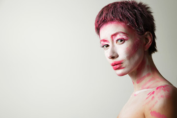 portrait of a girl with red paint on her face. isolated on white background