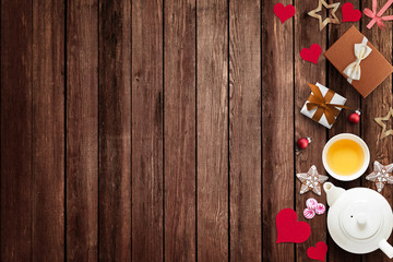 Christmas decoration on wooden table with cup of tea, gift boxes, gingerbread cakes, etc. Empty space for adding text, logo...