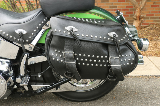 a black leather motorcycle saddlebag pannier with studs, fringes and buckles