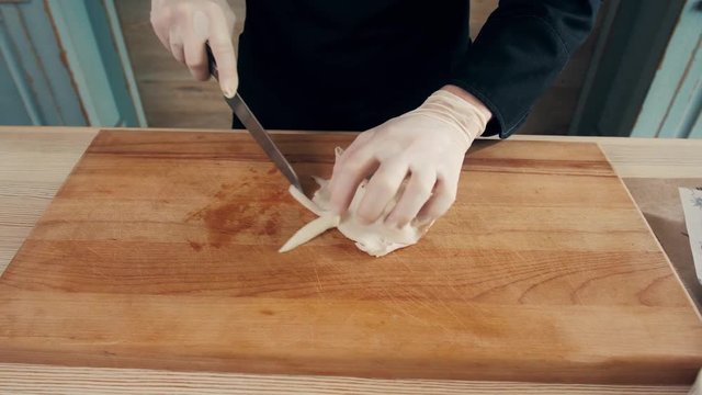 Cook hands is slicing of boiled squid. One of the stages of cooking calamaries. seafood restaurant top view