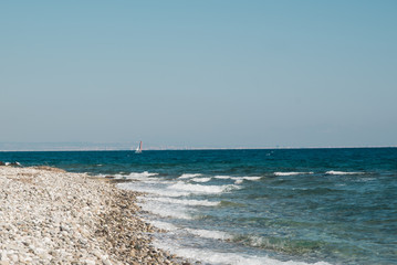 Small white sail yacht sailing in blue sea