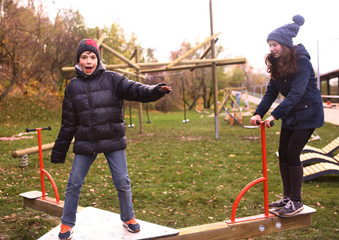 teenager siblings boy and girl in warm clothes having fun in autumn park on weekend © ulianna19970