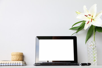 workspace desk with laptop and blank notebook and lilies Flower,business and technology concept
