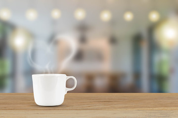 White coffee cup with heart shaped smoke on blurred cafe background