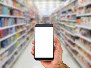 Man's hand holding blank white screen mobile phone on blurred supermarket background