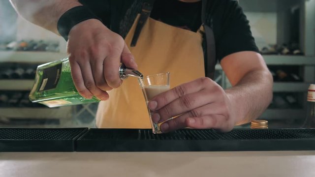 bartender prepares B52 Shot, cocktail preparation in modern bar with fire, tequilla vodka rum gin