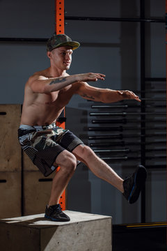 Brutal tattooed calisthenics coach shows exercise moves one leg squat