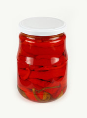 Jar of pickled red hot chili peppers over white