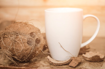 Tasty cocktail in white cup with coconut on wooden vintage table background
