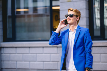 Smiling businessman in eyeglasses talking on the phone