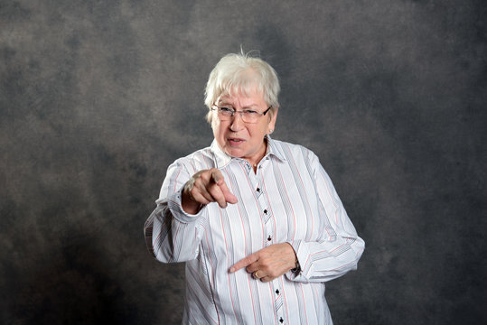 gray hairy elderly woman pointing in to the camera
