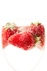 ripe juicy red strawberry in a glass with water