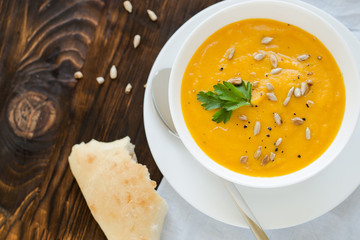 Dinner with carrot soup-puree served in white bowl