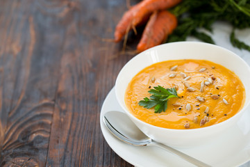 Dinner with carrot soup-puree served in white bowl