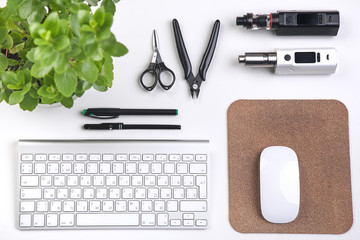 e-cig, keyboard, computer mouse, Green plant and phone